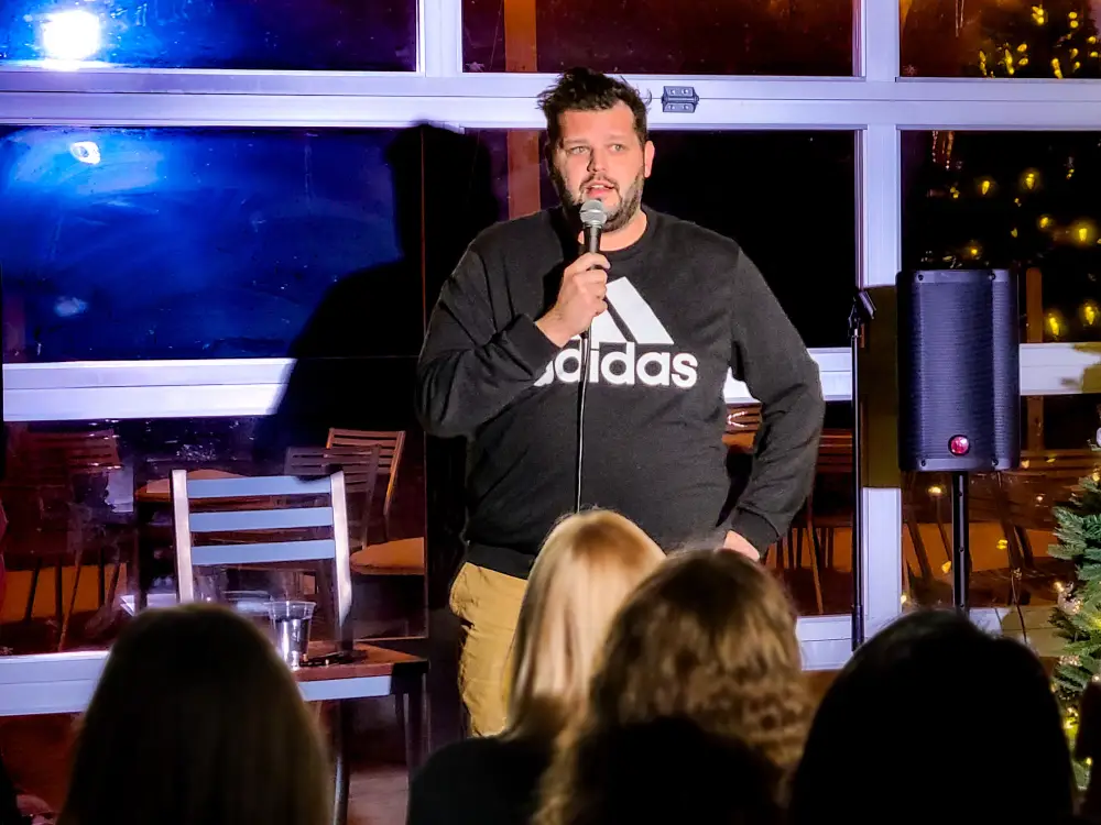 Comedian performing live stand-up comedy in front of an audience at Artisanal Brew Works restaurant in Saratoga Springs