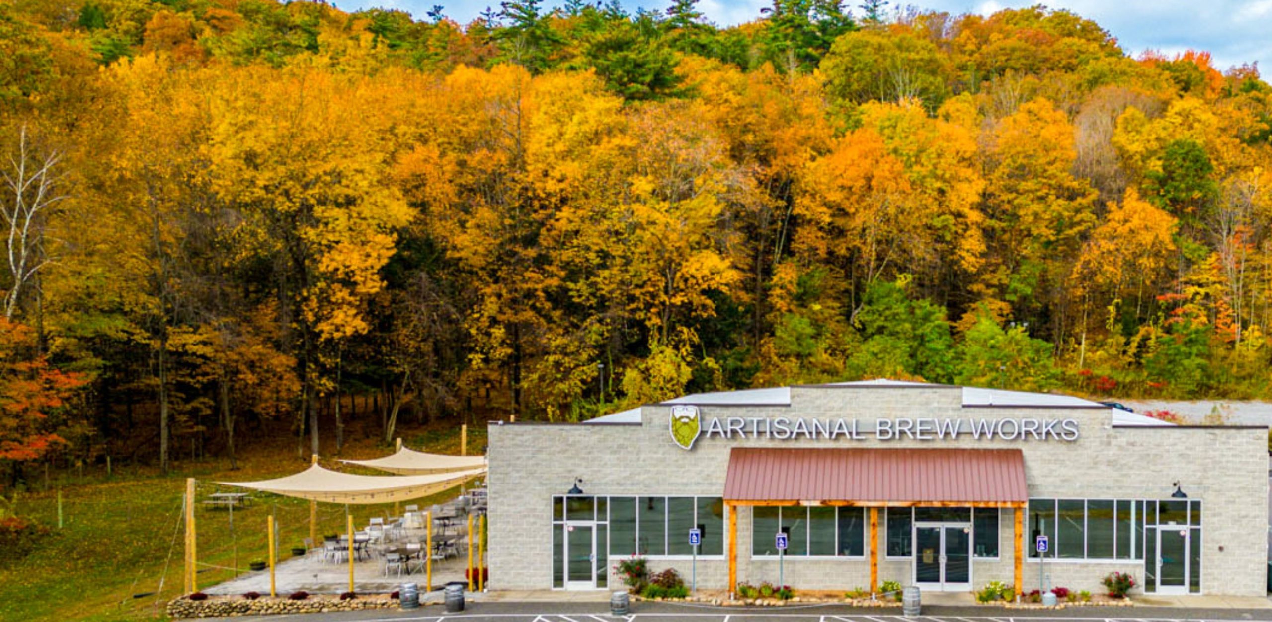 Artisanal Brew Works brewery and restaurant in Saratoga Springs NY surrounded by fall foliage and outdoor terrace