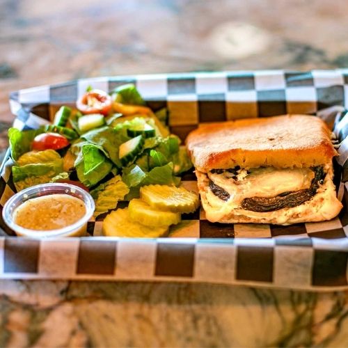 Portobello gouda panini with marinated mushroom, smoked gouda, grilled onions, and lemon aioli at a Saratoga Springs restaurant