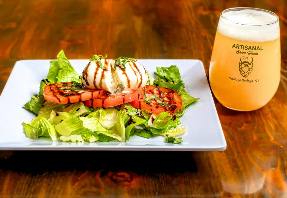 Burrata salad with fresh mozzarella, tomato and balsamic glaze served with beer at Nature’s Edge Bistro restaurant in Saratoga Springs