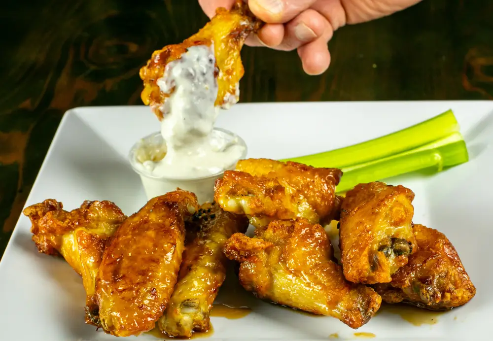 Crispy chicken wings dipped in blue cheese with celery at Nature’s Edge Bistro restaurant in Saratoga Springs