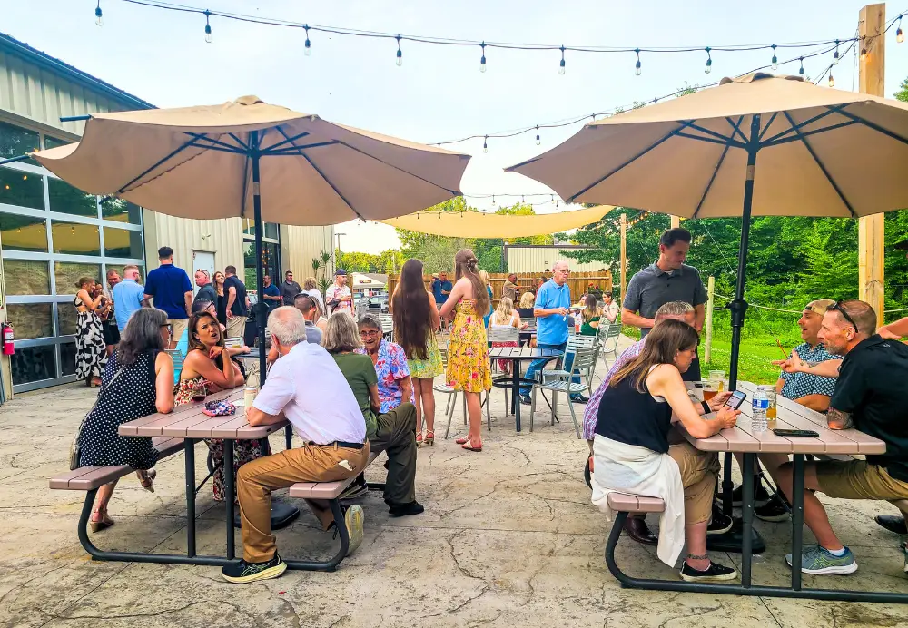 Outdoor dining on the Nature’s Edge Terrace at Artisanal Brew Works restaurant in Saratoga Springs with guests enjoying food and drinks
