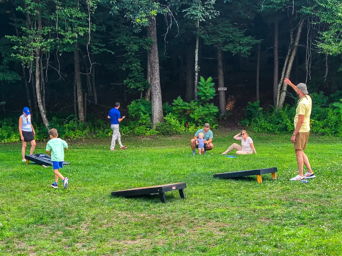 Families and kids playing lawn games at Artisanal Brew Works outdoor dining area in Saratoga Springs near the forest edge terrace