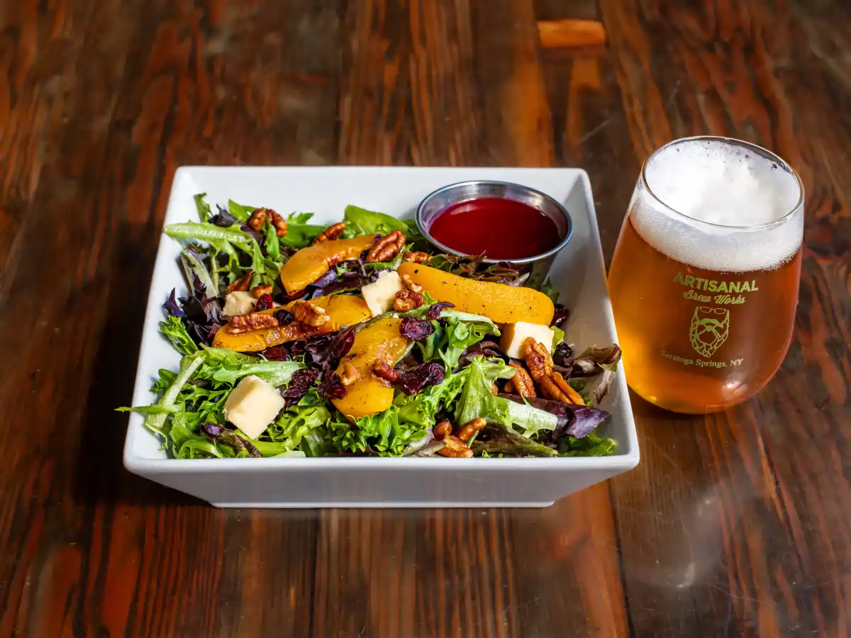 Fire roasted peach salad with candied pecans, sharp cheddar, craisins and raspberry vinaigrette at Nature’s Edge Bistro at Artisanal Brew Works restaurant in Saratoga Springs