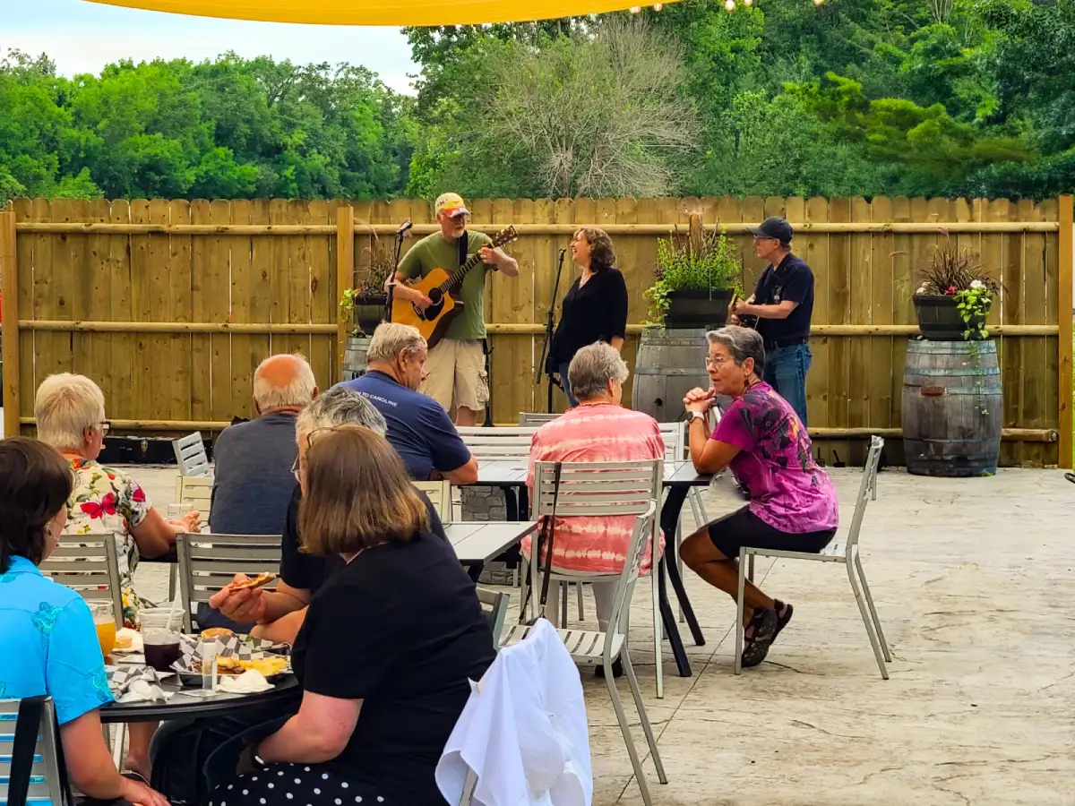 Live music performance at Artisanal Brew Works restaurant in Saratoga Springs with guests enjoying outdoor dining on the Nature’s Edge Terrace