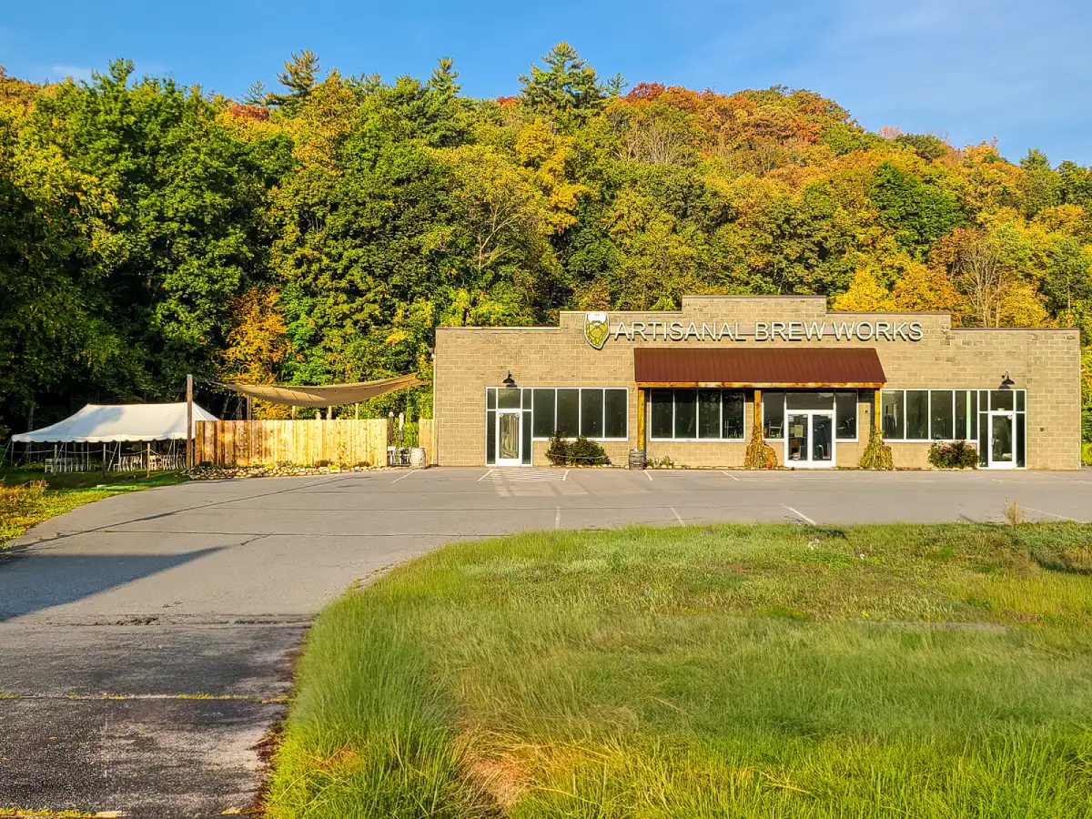 Exterior of Artisanal Brew Works restaurant in Saratoga Springs with Nature’s Edge Terrace and forest backdrop